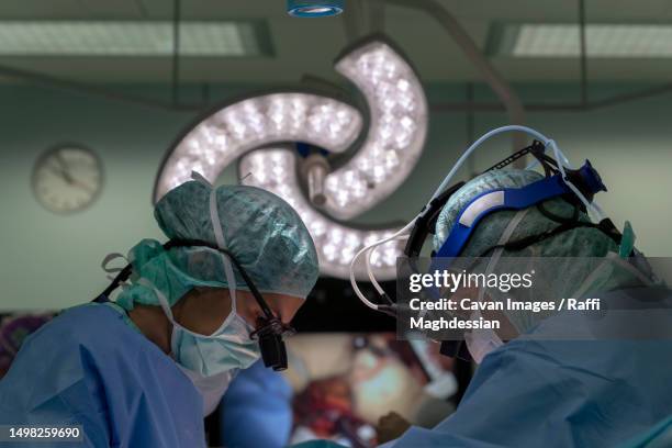 two cardiac surgeons operating on a patient - laparoscopy 個照片及圖片檔