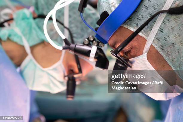 two cardiac surgeons during a surgical intervention - herzoperation stock-fotos und bilder