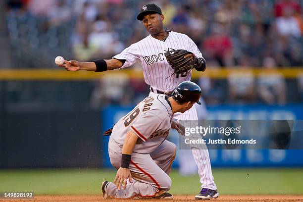 Jonathan Herrera of the Colorado Rockies throws to first base after recording the lead out at second base as Marco Scutaro of the San Francisco...