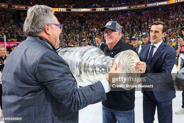 General Manger Kelly McCrimmon of the Vegas Golden Knights, left, hands the Stanley Cup to owner Bill Foley after defeating the Florida Panthers to...