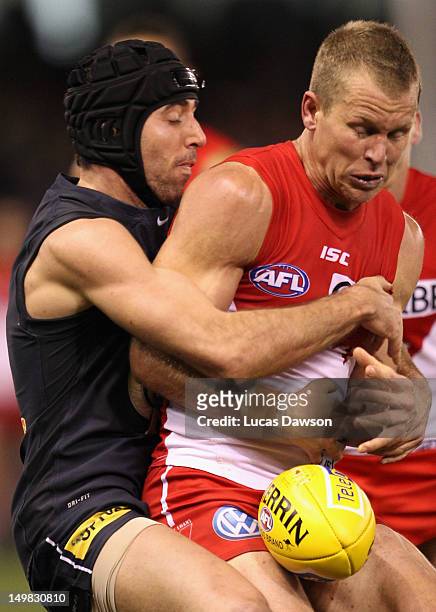 Kade Simpson of the Blues tackles Ryan O'Keefe of Swans during the round 19 AFL match between the Carlton Blues and the Sydney Swans at Etihad...