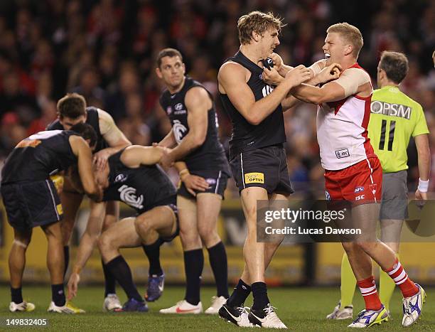 Tom Bell of the Blues and Daniel Hannebery of the Swans wrestle during the round 19 AFL match between the Carlton Blues and the Sydney Swans at...