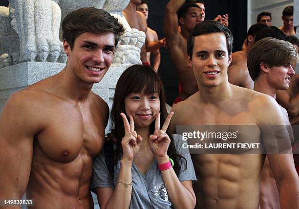 Local woman poses for photographs with topless male models outside the soon to open Abercrombie & Fitch flagship clothing store in Hong Kong on...