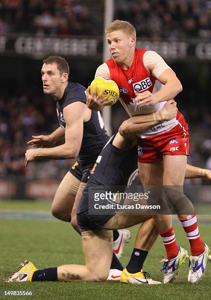 Daniel Hannebery of the Swans is tackled during the round 19 AFL match between the Carlton Blues and the Sydney Swans at Etihad Stadium on August 5,...