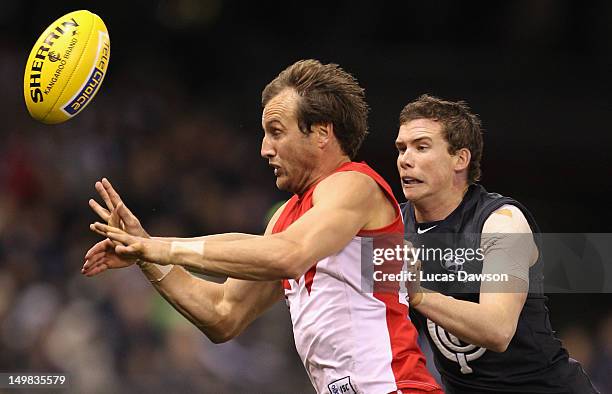 Andrew Collins of the Blues tackles Jude Bolton of the Swans during the round 19 AFL match between the Carlton Blues and the Sydney Swans at Etihad...
