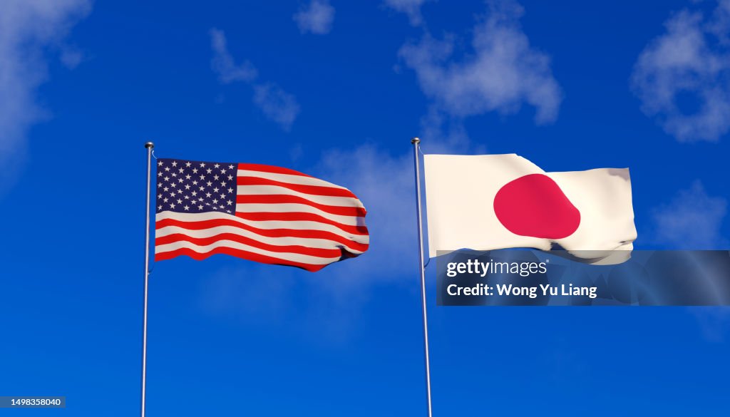 USA and Japan flags on blue sky
