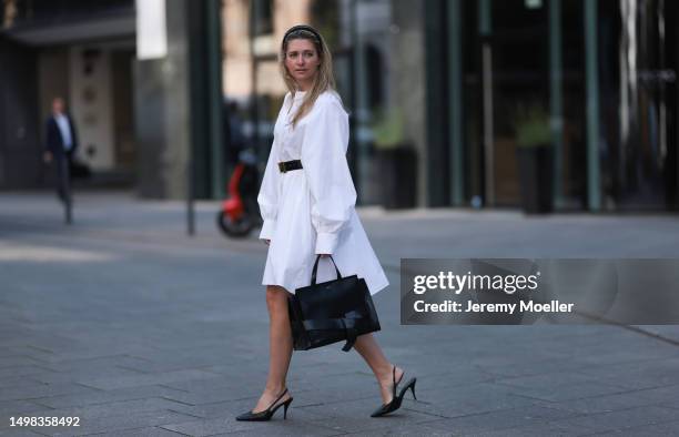 Josephine Kröger wearing black Hermes belt, black Saint Laurent heels, white SoSue dress, black naditum bag on June 08, 2023 in Hamburg, Germany.