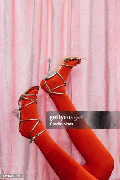 legs in heels upside down of an unrecognizable woman with red bushy stockings and pink velvet background - nylon feet 個照片及圖片檔