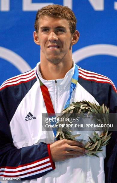 Michael Phelps poses on the podium after winning the men's 200m individual medley final, at the 2004 Olympic Games at the Olympic Aquatic Center in...