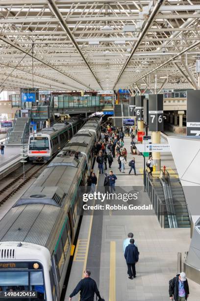 lot's of people exiting and boarding a train at the perth train station - perth train station stock pictures, royalty-free photos & images