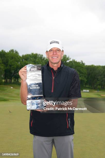 Steve Stricker of United States holds the winner's trophy on the 18th green after winning the American Family Insurance Championship at University...