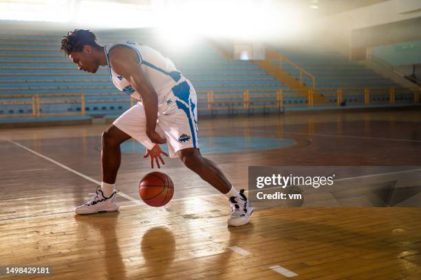 jugador de baloncesto regateando balón mientras entrena - competición de baloncesto fotografías e imágenes de stock