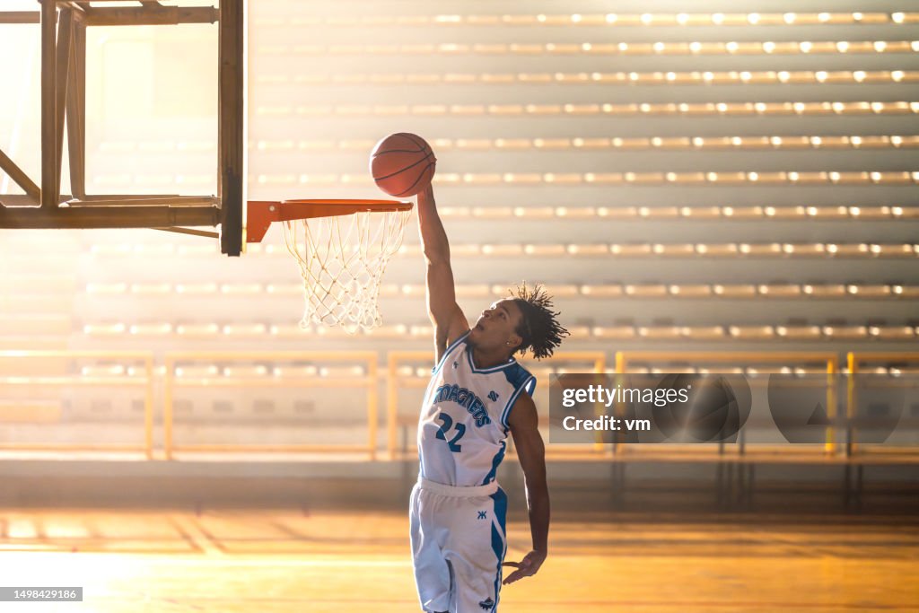Basketball player throwing ball through hoop