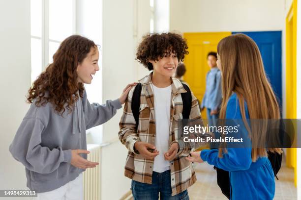 studenti che parlano insieme in un corridoio della scuola - school boy girl foto e immagini stock
