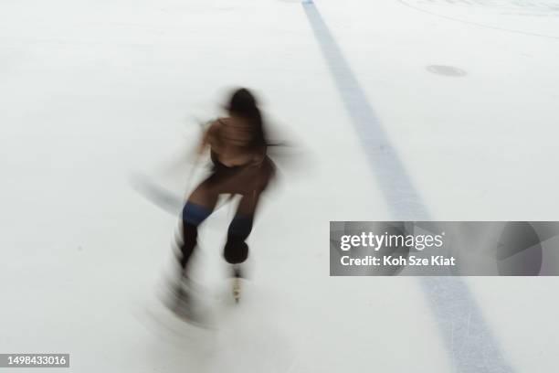 黒いレオタードを着たアジアの女性フィギュアスケート選手がスケートのルーチンを練習している - ice skate ストックフォトと画像