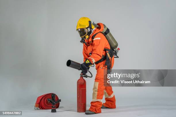 firefighter with mask and protective suit on a white background. - roupa à prova de fogo imagens e fotografias de stock