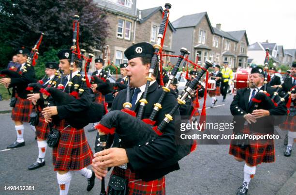 Led by pipers, members of the Society of William Wallace take part in a memorial march along a road in the centre of the town of Lanark in South...