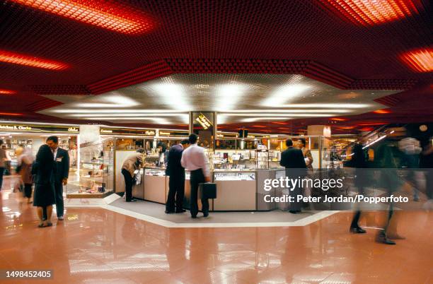 Customers and travellers are served by sales assistants at a counter selling watches and jewellery in a Duty Free shop at Dubai International Airport...