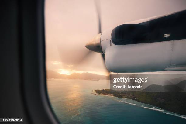 flight above seychelles islands at beautiful sunset - propeller plane stockfoto's en -beelden