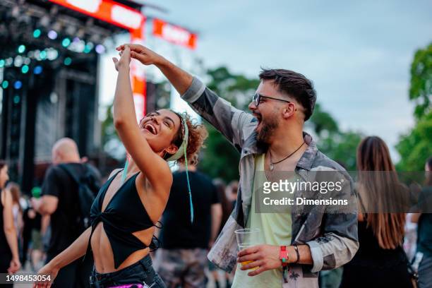 dancing couple at concert - festival stock pictures, royalty-free photos & images