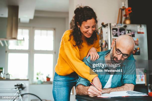 man and woman discussing over financial bills at home - arab mature couple stock pictures, royalty-free photos & images