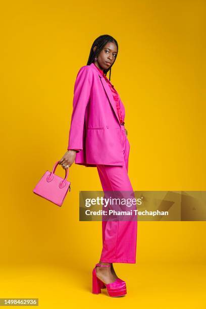 fashionable woman in pink suit - bolso dorado fotografías e imágenes de stock