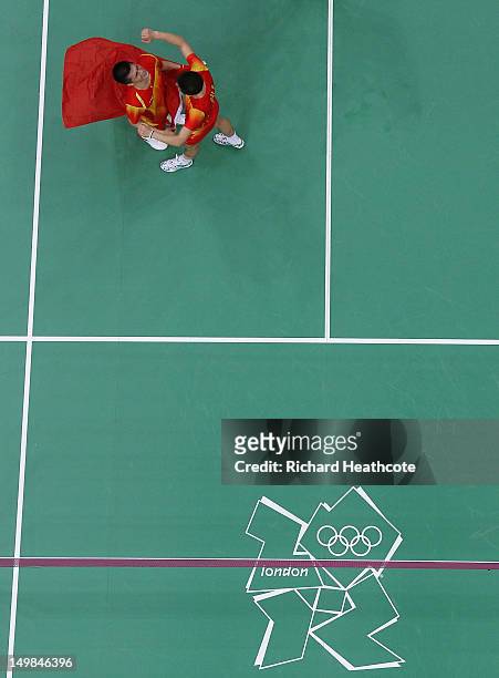 Yun Cai and Haifeng Fu of China celebrate victory against Mathias Boe and Carsten Mogensen of Denmark in their Men's Doubles Badminton Gold Medal...