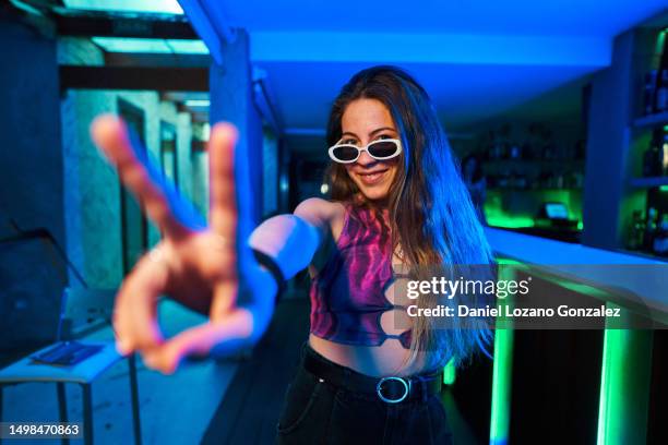 woman in a disco gesturing success with fingers - rebellion stock pictures, royalty-free photos & images