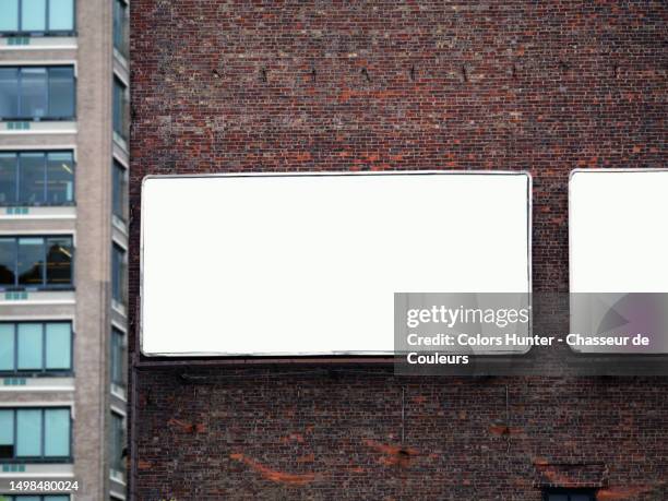 rectangular and empty billboards on a patinated brick wall and, in the background, an office building in manhattan, new york state, united states - us blank billboard stock pictures, royalty-free photos & images