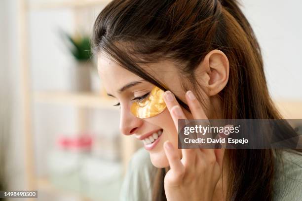 close-up of a woman applying anti-dark circles patches - one eyed stock pictures, royalty-free photos & images