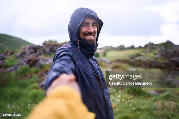man pulling his girlfriend hand under the rain, outdoors in the natural landscape. - subjektive kamera ungewöhnliche ansicht stock-fotos und bilder