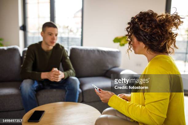 caring female therapist talking with insecure teenage boy - child psychologist stock pictures, royalty-free photos & images