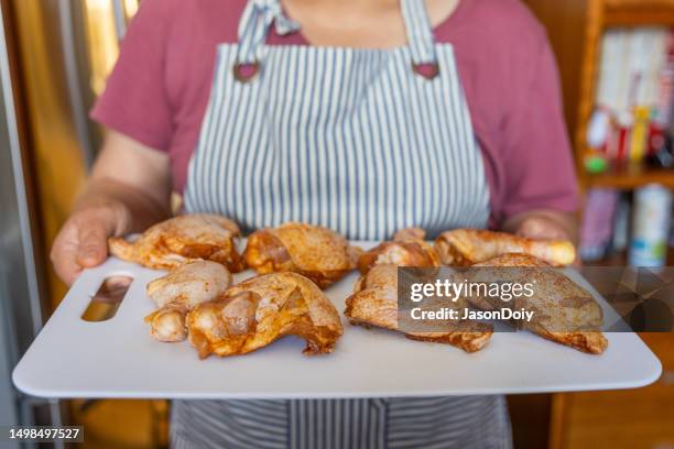 frau bereitet hühnchen zum grillen vor - chicken thigh stock-fotos und bilder