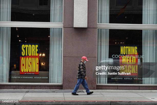 Pedestrian walks by a store that is closing on June 14, 2023 in San Francisco, California. San Francisco's downtown continues to struggle with...