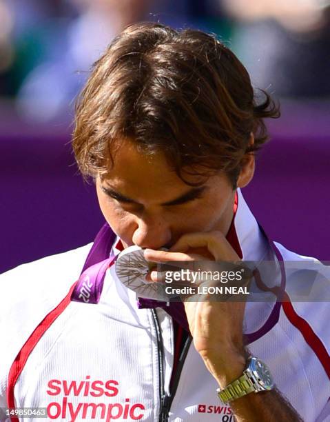 Switzerland's Roger Federer poses on the podium with his silver medal, at the end of the men's singles tennis tournament of the London 2012 Olympic...