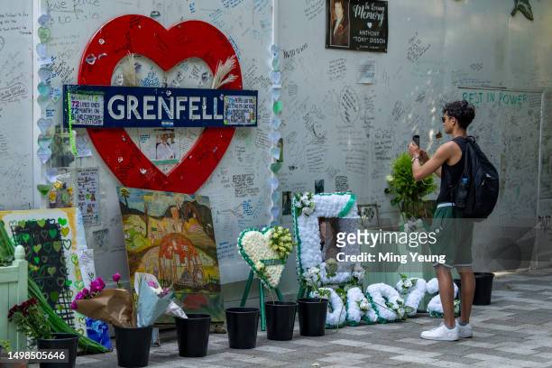 Person takes a picture of the tribute wall outside Grenfell Tower on June 14, 2023 in London, England. A fire broke out in Grenfell Tower, North...