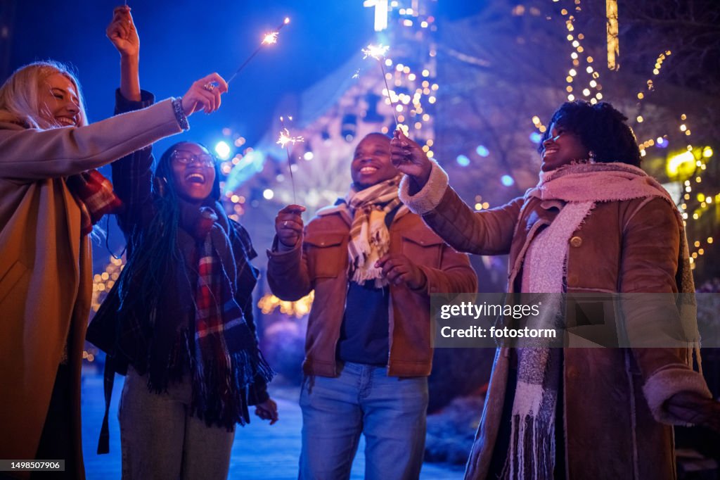 Friends at the New Year's eve concert dancing and waving sparklers