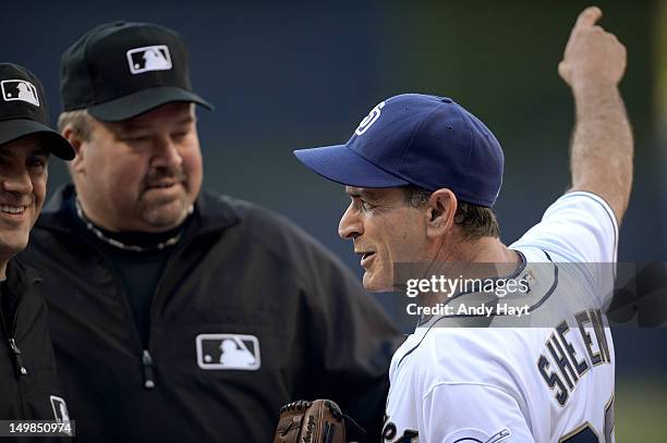 Actor Charlie Sheen talks to umpire Wally Bell after throwing a ceremonial first pitch prior to the game against the San Diego Padres and the...