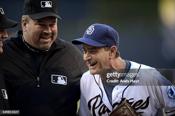 Actor Charlie Sheen talks to umpire Wally Bell after throwing a ceremonial first pitch prior to the game against the San Diego Padres and the...