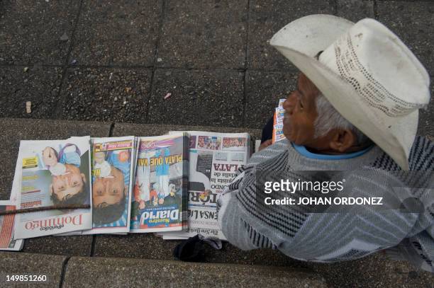 Newsvendor offers local papers with the picture of Guatemalan Erick Barrondo, winner of Guatemala's first Olympic medal on their front page, on...
