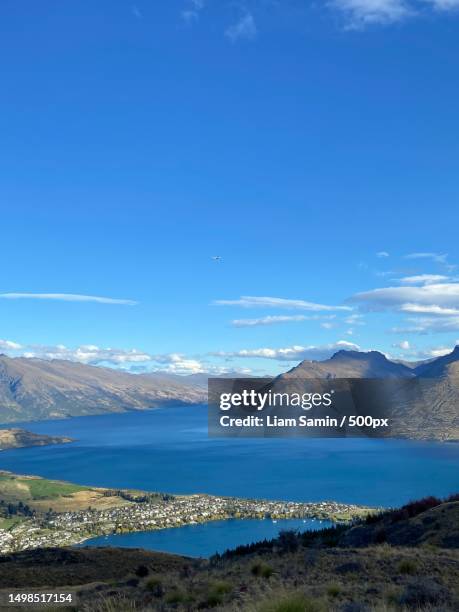 scenic view of lake and mountains against blue sky,queenstown,new zealand - liam stock pictures, royalty-free photos & images