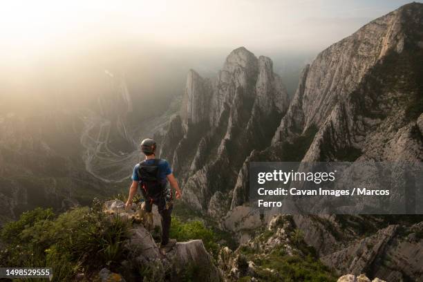 one man standing on a cliff on his way to nido de aguiluchos huasteca - nuevo leon state stock pictures, royalty-free photos & images