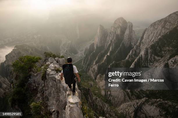 one man walking on a narrow edge on a high exposed area in la huasteca - höhenangst stock-fotos und bilder