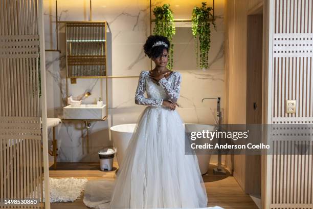 femme noire habillée en mariée dans une chambre d’hôtel - célibataire femme photos et images de collection