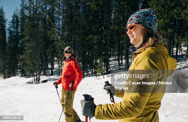 two young women cross-country ski on mt. hood on a sunny day - mt hood stock pictures, royalty-free photos & images