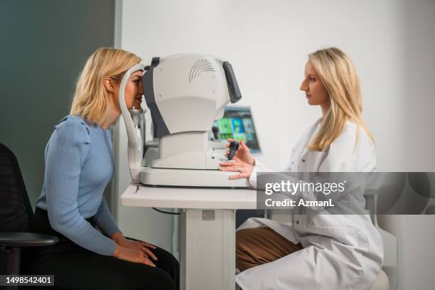 side view of patient and ophthalmologist indoors - eye scanner stock pictures, royalty-free photos & images