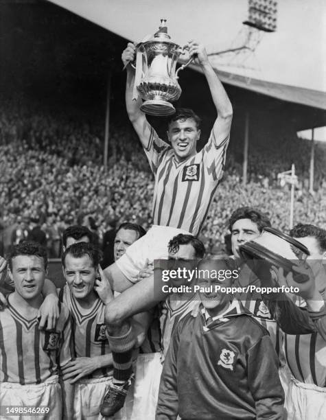 Aston Villa captain Johnny Dixon is chaired by team members after they beat Manchester United 2-1 to win the FA Cup in the final at Wembley Stadium,...