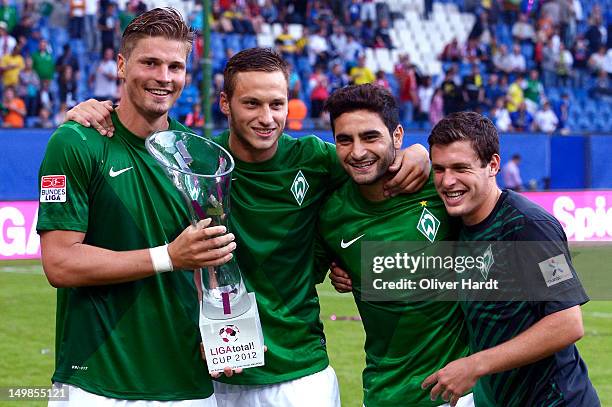 Sebastian Proedl , Marko Arnautovic , Mehmet Ekici and Zlatko Junuzovic of Bremen celebrate with the trophy after winning the LIGA total! Cup 2012...