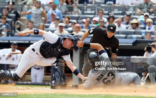 Chris Stewart of the New York Yankees tags out Jesus Montero of the Seattle Mariners to end the first inning at Yankee Stadium on August 5, 2012 in...