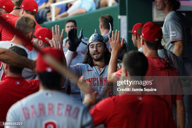 Jonathan India of the Cincinnati Reds is congratulated by teammates in the dugout after hitting a home run during the 5th inning of the game against...